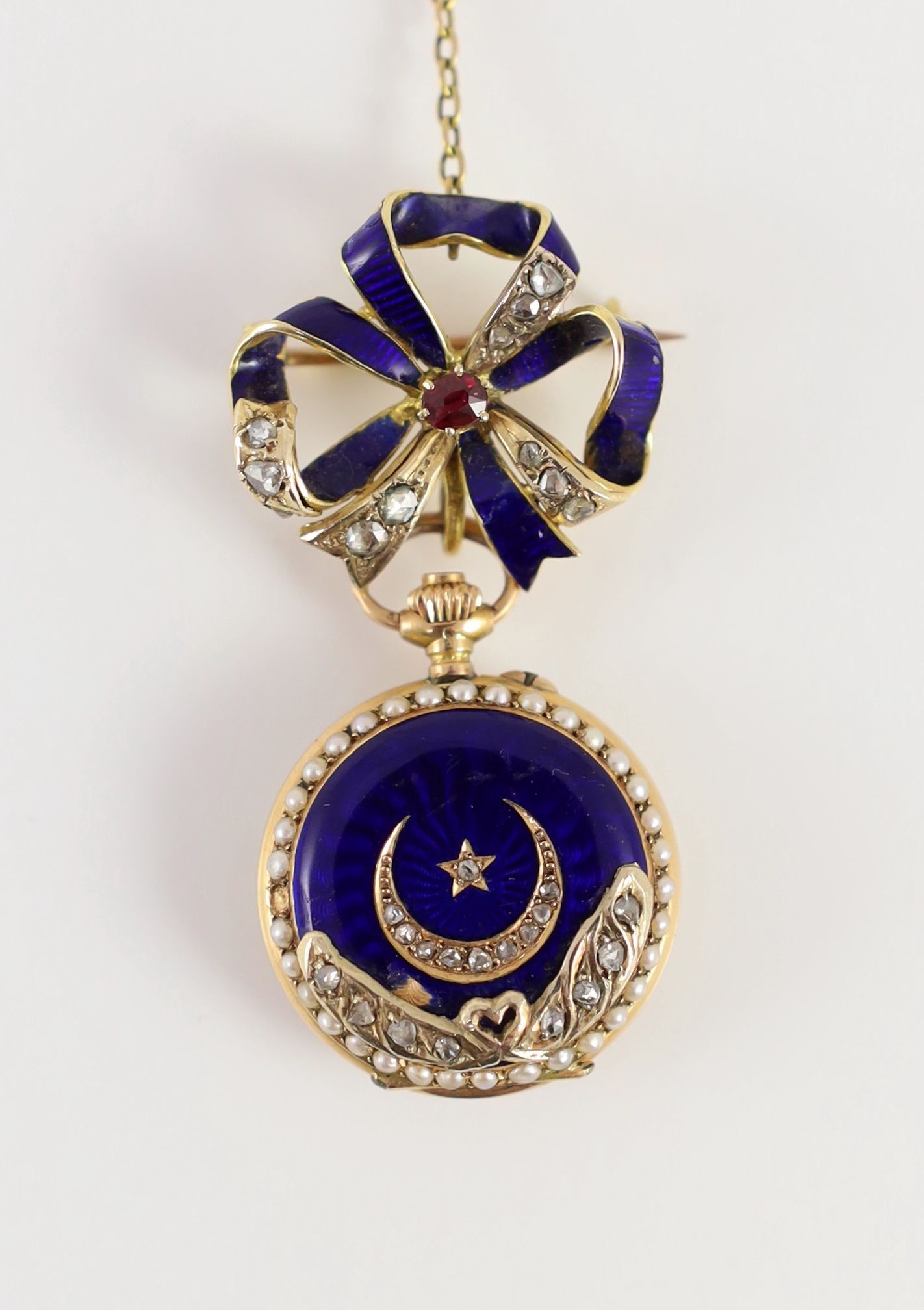 A lady's late 19th/early 20th century Swiss 18ct gold, enamel, split pearl and diamond set fob watch, on an associated 18ct gold, enamel, ruby and diamond set ribbon bow suspension brooch